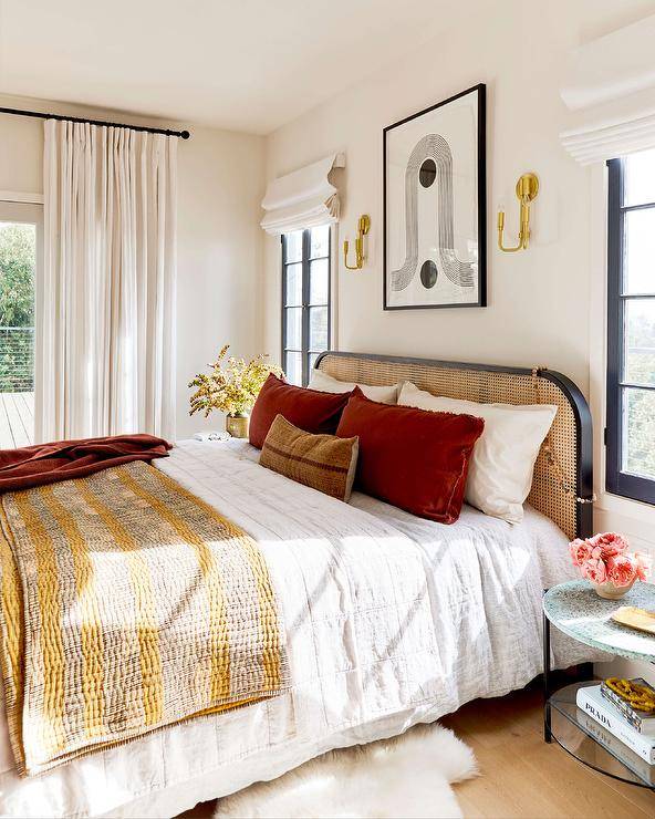 modern boho bedroom with wall art black frame bed mustard yellow bedspread red velvet curtains