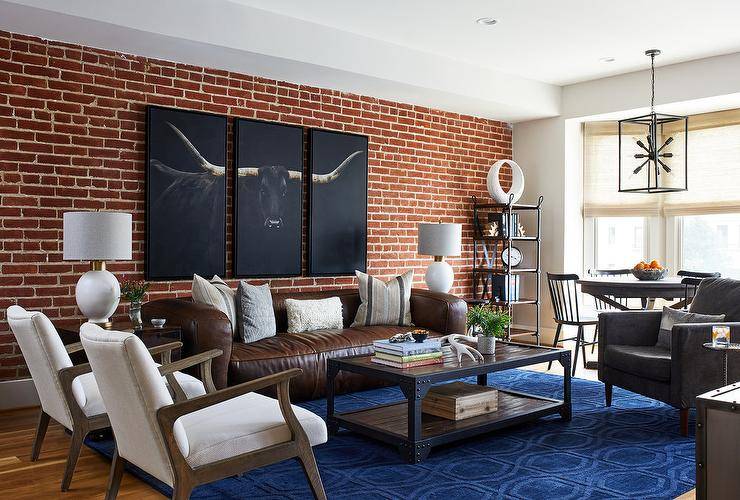 red brick wall in living room with brown leather couch texas longhorn wall art sitting chairs