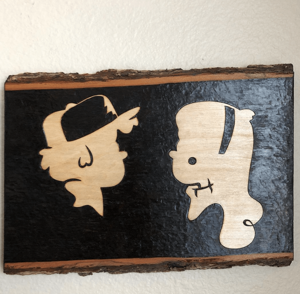 two faces side profile on live edge wood piece wood burning