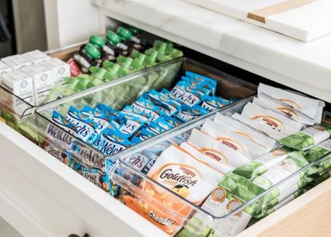 pull out snack drawer in kitchen goldfish packages white cabinetry close up