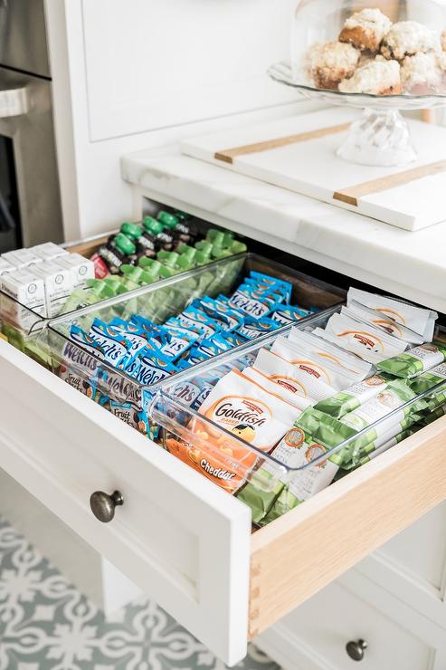 pull out snack drawer in kitchen goldfish packages white cabinetry close up