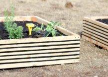 black and wood striped raised garden bed with top soil