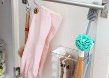 towel bar on inside of cupboard door close up hanging gloves scrub brush
