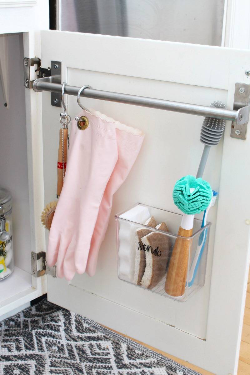 towel bar on inside of cupboard door close up hanging gloves scrub brush