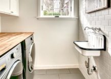 white subway tile wall mounted sink black and white butcher block counter top over stainless steel washer and dryer side by side