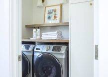 hexagon marble tile floor laundry room side by side washer and dryer stainless steel white gold wall sconce wood top counter folded towels