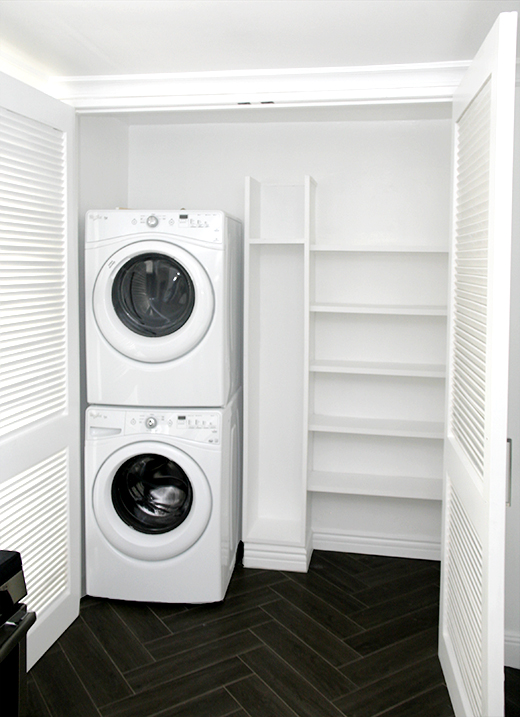 white built in shelves in closet laundry room empty washer and dryer stacked