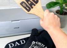 hand holding up wood bbq scraper dad fathers day gift ideas cricut maker 3 black oven mitts plant