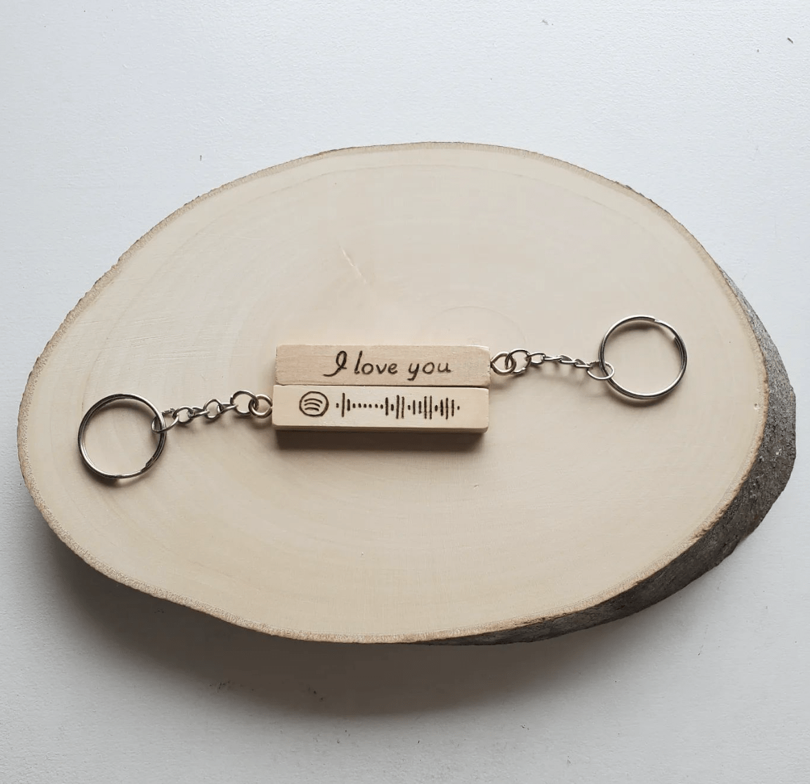 wood keychain on wood log slice white background