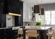 black kitchen cabinetry and island with gold and blush stools hanging pendants