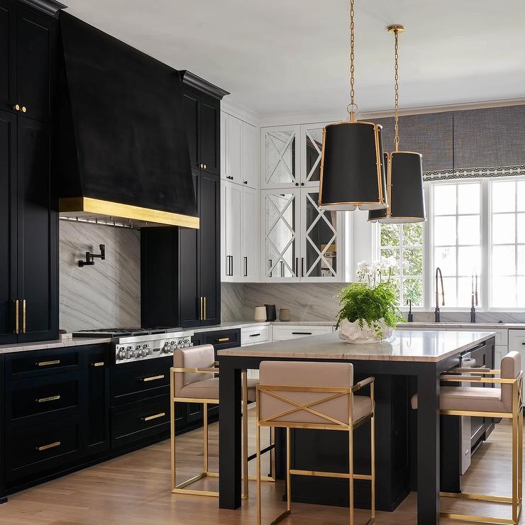 black kitchen cabinetry and island with gold and blush stools hanging pendants