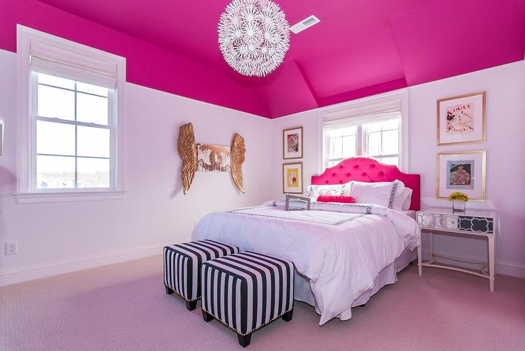 hot pink and white girl's bedroom two black and white striped cube ottomans positioned in front of a bed ot pink tufted head board and a hot pink bolster pillow