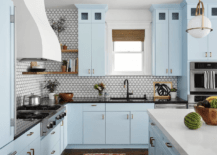 blue kitchen cabinetry patterned tile back bamboo shadessplash white globe hanging pendants white range hood