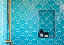 Shower features turquoise blue scale tiles, a blue scale tiled shower niche and a brass shower head.