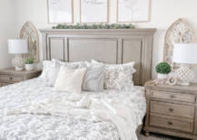 white and wood farmhouse bedroom with matching nightstands and arch windows behind greenery