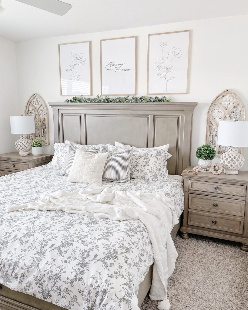 white and wood farmhouse bedroom with matching nightstands and arch windows behind greenery