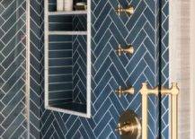 Blue tiled stacked shower niches are framed by blue herringbone shower wall tiles.