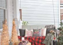 christmas porch decor swing with burlap wrapped trees red and black plaid blanket pillow rubber boots