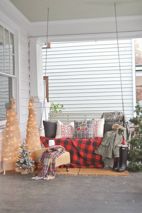 christmas porch decor swing with burlap wrapped trees red and black plaid blanket pillow rubber boots