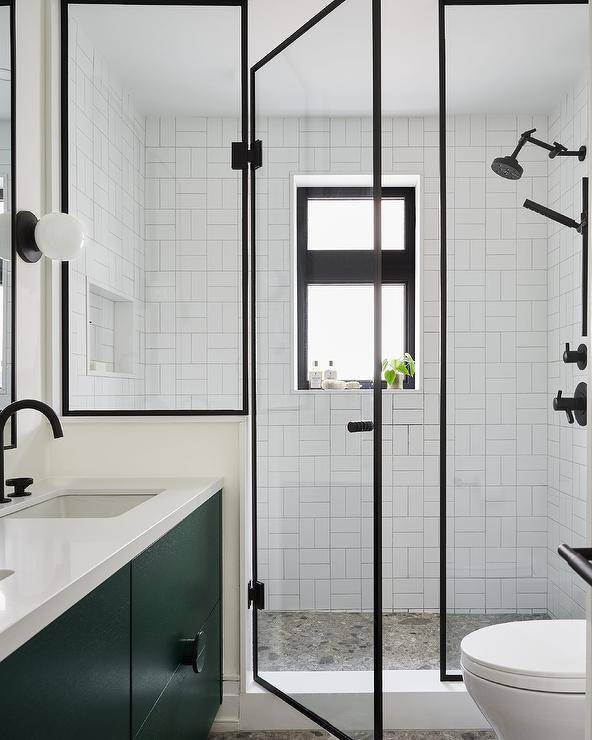 steel and glass shower door enclosure accent walk-in shower with an oil rubbed bronze shower head mounted against white subway basketweave wall tiles
