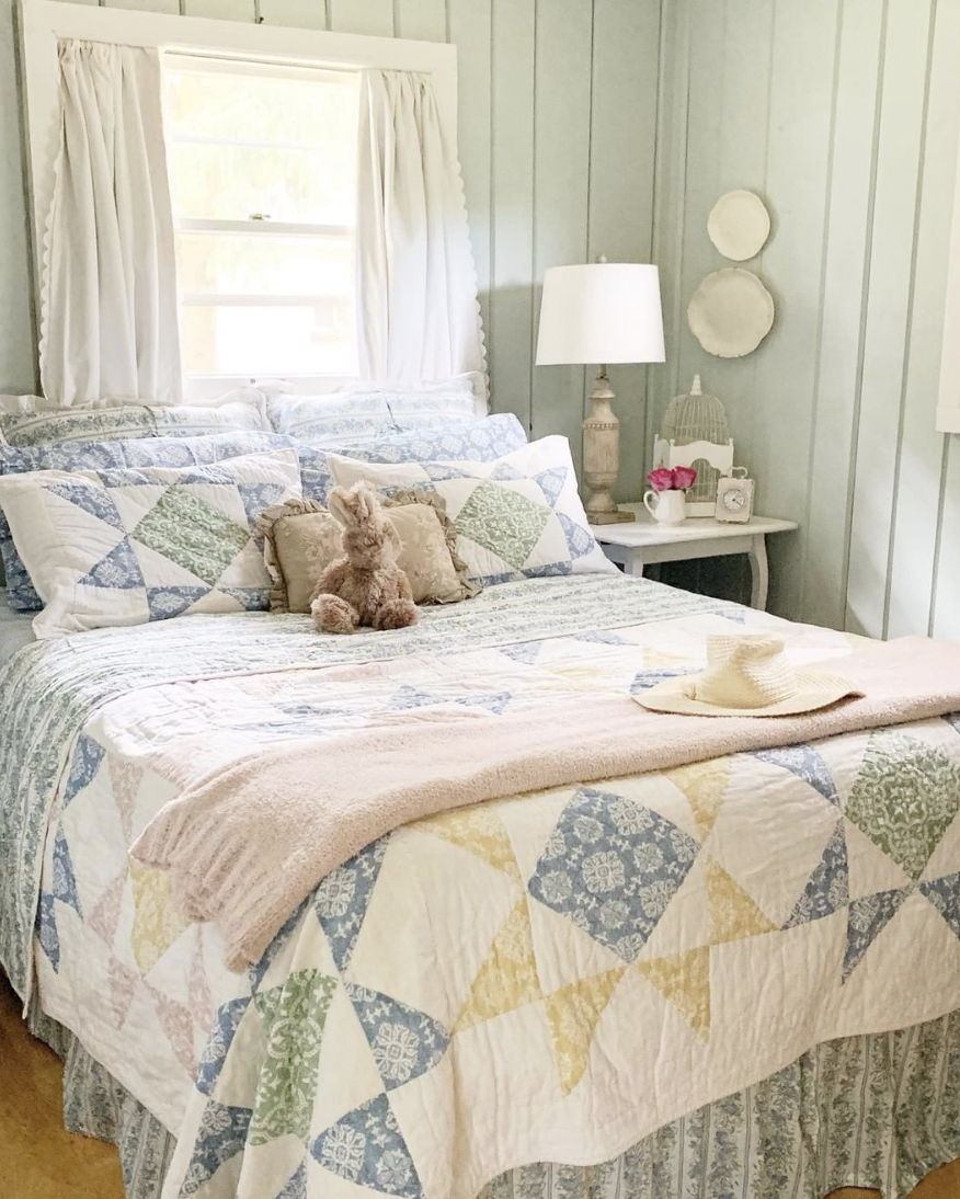 farmhouse bed in mint green batten wall bedroom with quilts and pillows