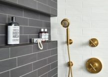 Dark gray glazed tiles walk-in shower with white grout and a brushed gold shower kit