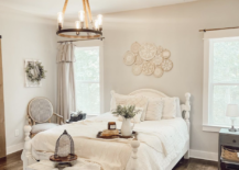 white farmhouse bedroom bed with white bedding and embroidery hoop art hanging over bed rope chandelier