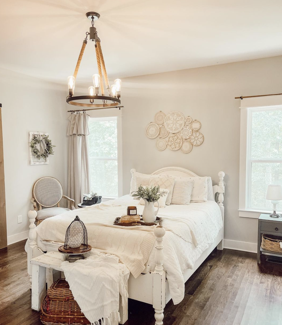 white farmhouse bedroom bed with white bedding and embroidery hoop art hanging over bed rope chandelier