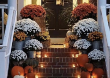 mums on fall porch up steps lit up rustic wreath on black door small pumpkins