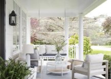 large view of front porch with white sitting chairs coffee table outdoor rug and fern in pot