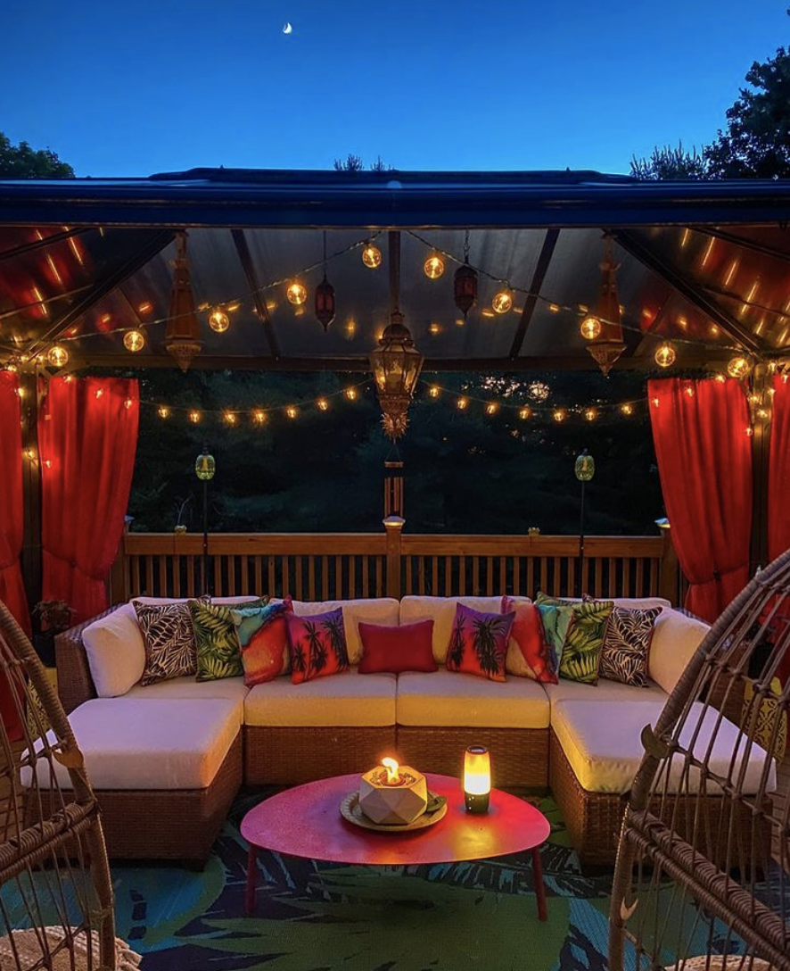 string lights under metal gazebo red curtains outdoor sectional coffee table