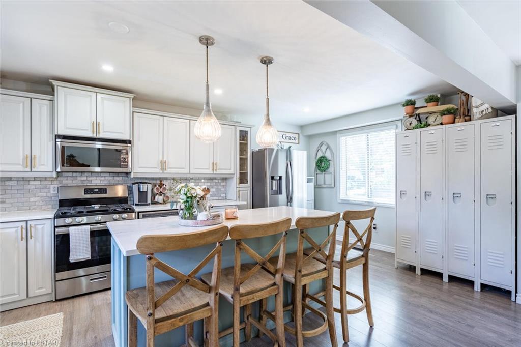 bright kitchen wide shot island with wood stools white lockers hanging pendants grey cabinets