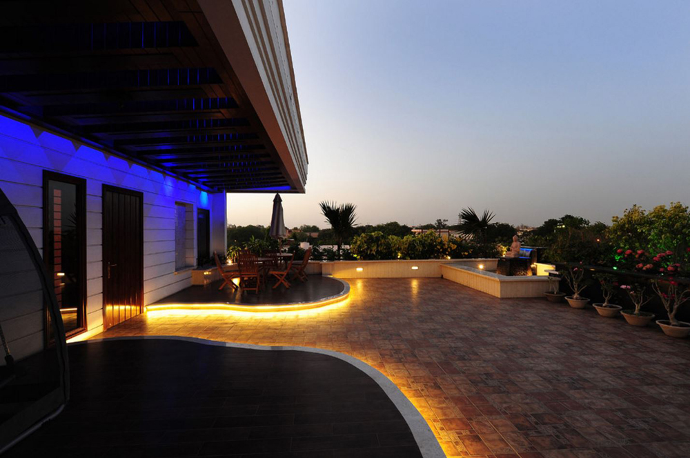 Landscape lighting led tape lighting around deck and patio backyard of house lit up at night