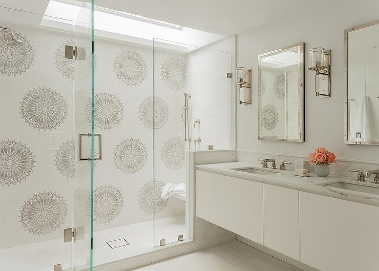 White and gray mosaic surround tiles seamless glass shower fitted beneath a skylight floating bench mounted against white tiles