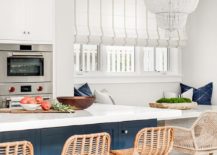 white and blue kitchen with rattan island stools white chandelier and large roman striped shade