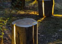 cracked log lamps on pathway in garden lit up at night