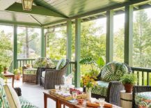 covered porch greek plank vaulted ceiling furnished with teak accent tables placed side-by-side between a dark brown wicker sofa with green cushions facing two matching dark brown wicker chairs