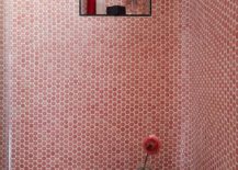 Contemporary shower features pink penny tiles with white grout, a pink tiled shower and a black accent table.