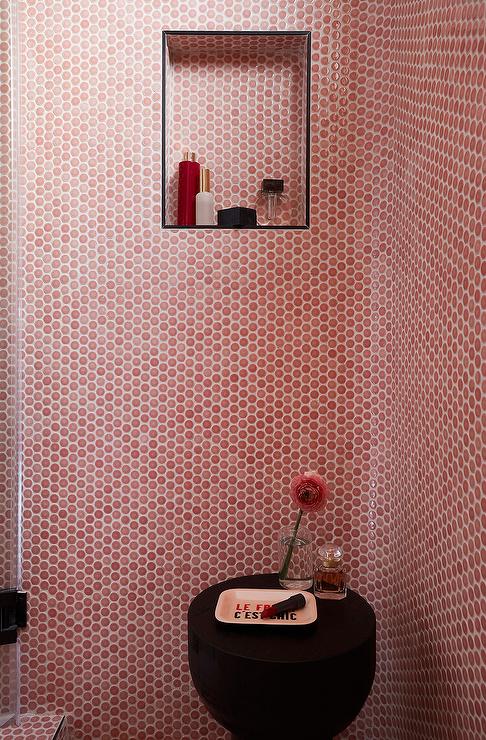 Contemporary shower features pink penny tiles with white grout, a pink tiled shower and a black accent table.