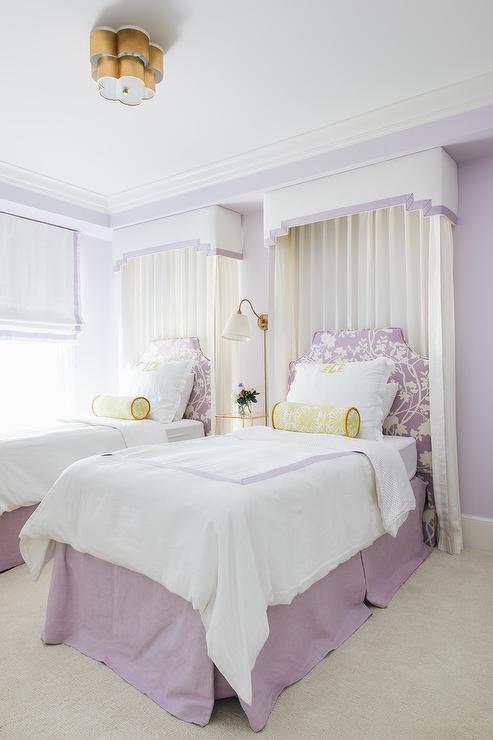 purple and yellow twin beds with valance and curtains behind