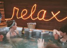 rope light relax outdoor sign lit up people in hot tub drinking