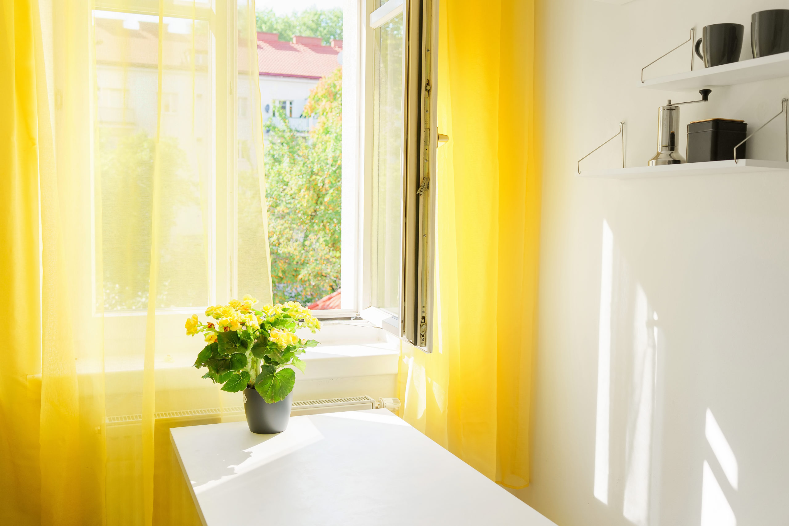 Window at the kitchen with bright yellow curtains. Positive colors. Illuminating yellow. Stress reducing concept. Comfort zone. Interiors