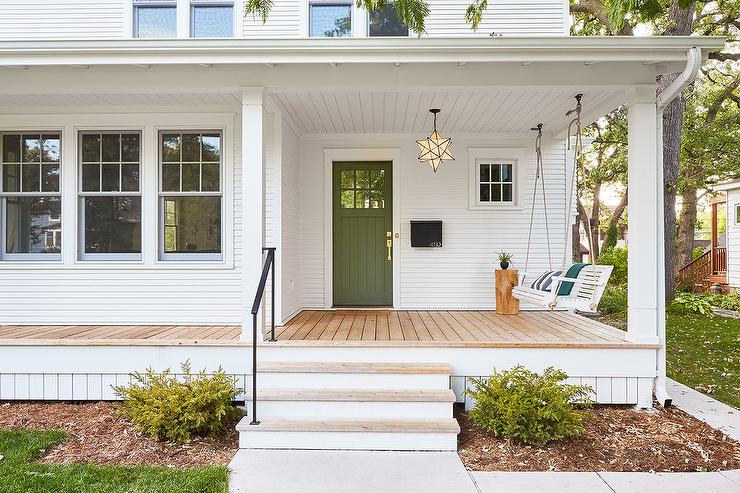 simple white and wood front porch with green door and hanging swing star chandelier