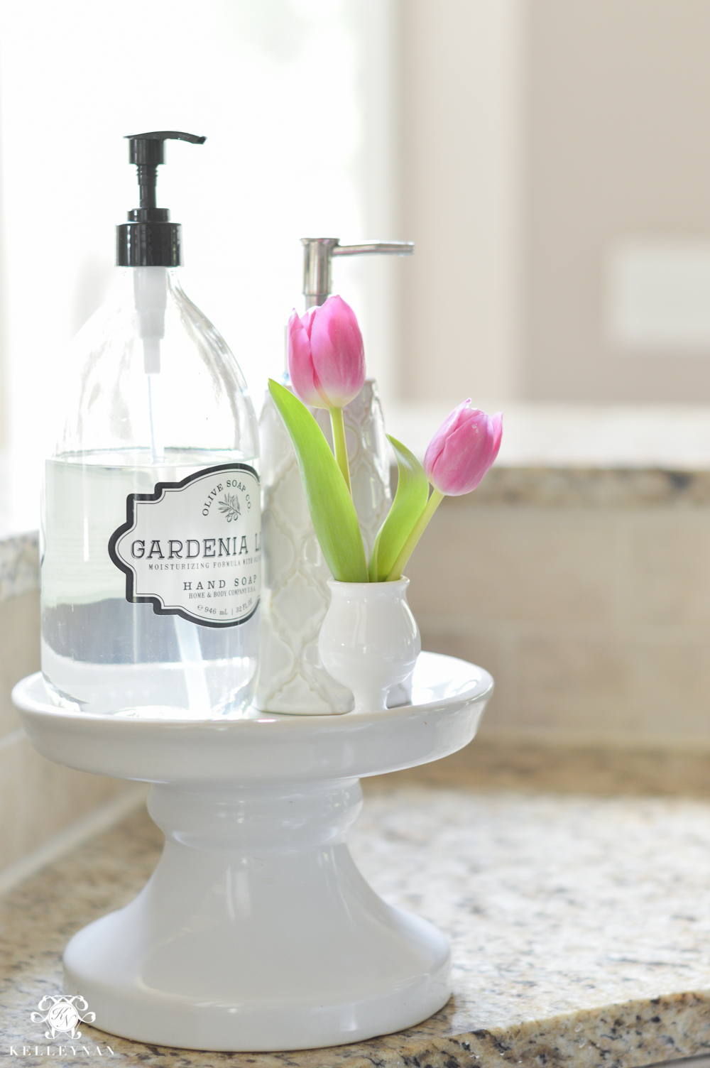 white soap stand in kitchen with clear glass soap bottle pink tulips