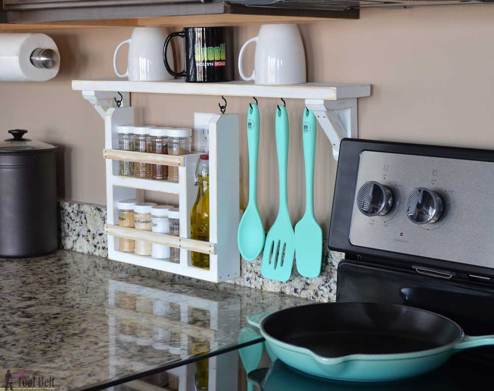 white wood spice rack and utensil holder on kitchen backsplash next to stove