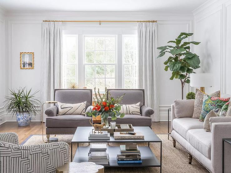 staged modern living room with grey sitting chairs white couch light bright window