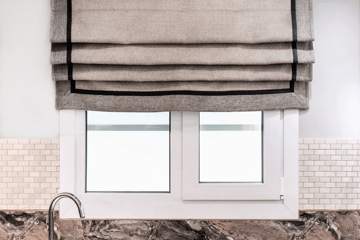 textured roman shade close up in kitchen with white tile and marble counter