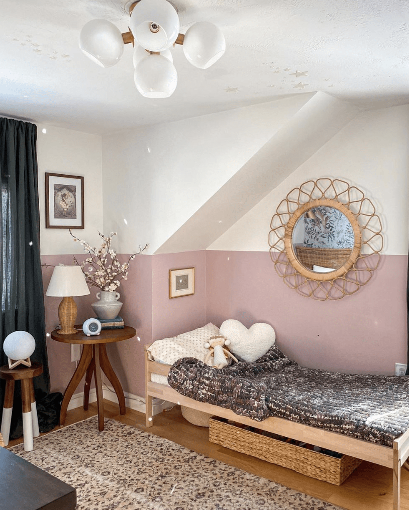 little girls bedroom with half white half pink wall wood rattan round mirror small wood bed with storage underneath