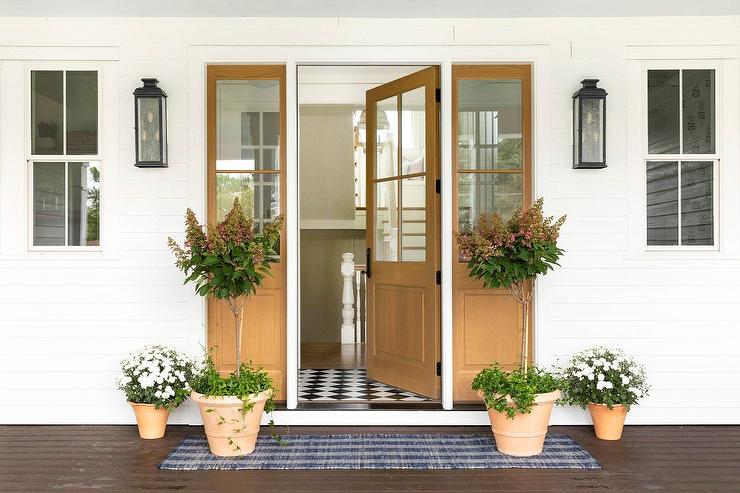 front porch of house with wood door open to inside clay terracotta pots on porch