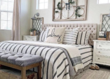 large master farmhouse bedroom with old window above bed tufted headboard decorative throw pillows